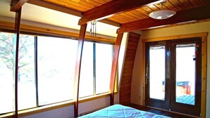A bedroom with a bed, large windows, and a door leading outside. - A Grandview over Capitol Reef National Park (Torrey)