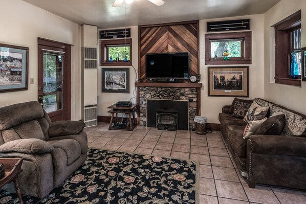 A living room with a fireplace, a television, and a large rug.
