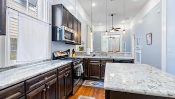 A kitchen with dark wooden cabinets, a stainless steel range, and a granite countertop.