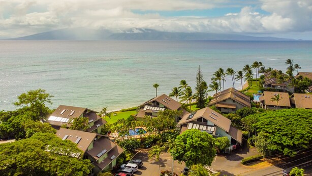 A coastal residential area with houses, a swimming pool, and a view of the ocean. - Experience paradise at Kahana's beachfront 3-bedroom condo near Kaanapali Beach  (Lahaina)