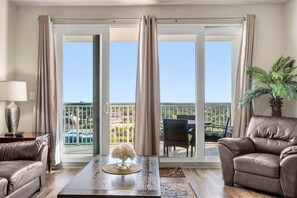 Enjoy a city view from the balcony, featuring a sofa and pool in the distance.