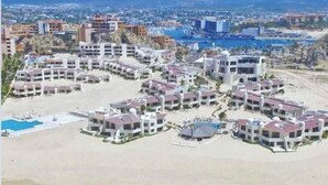 A resort with multiple buildings, a pool, and a beach area. - ALL NEW remodeled condo! Ocean Front on Beach 2 Bd 2 Ba Upper Level (Cabo San Lucas)