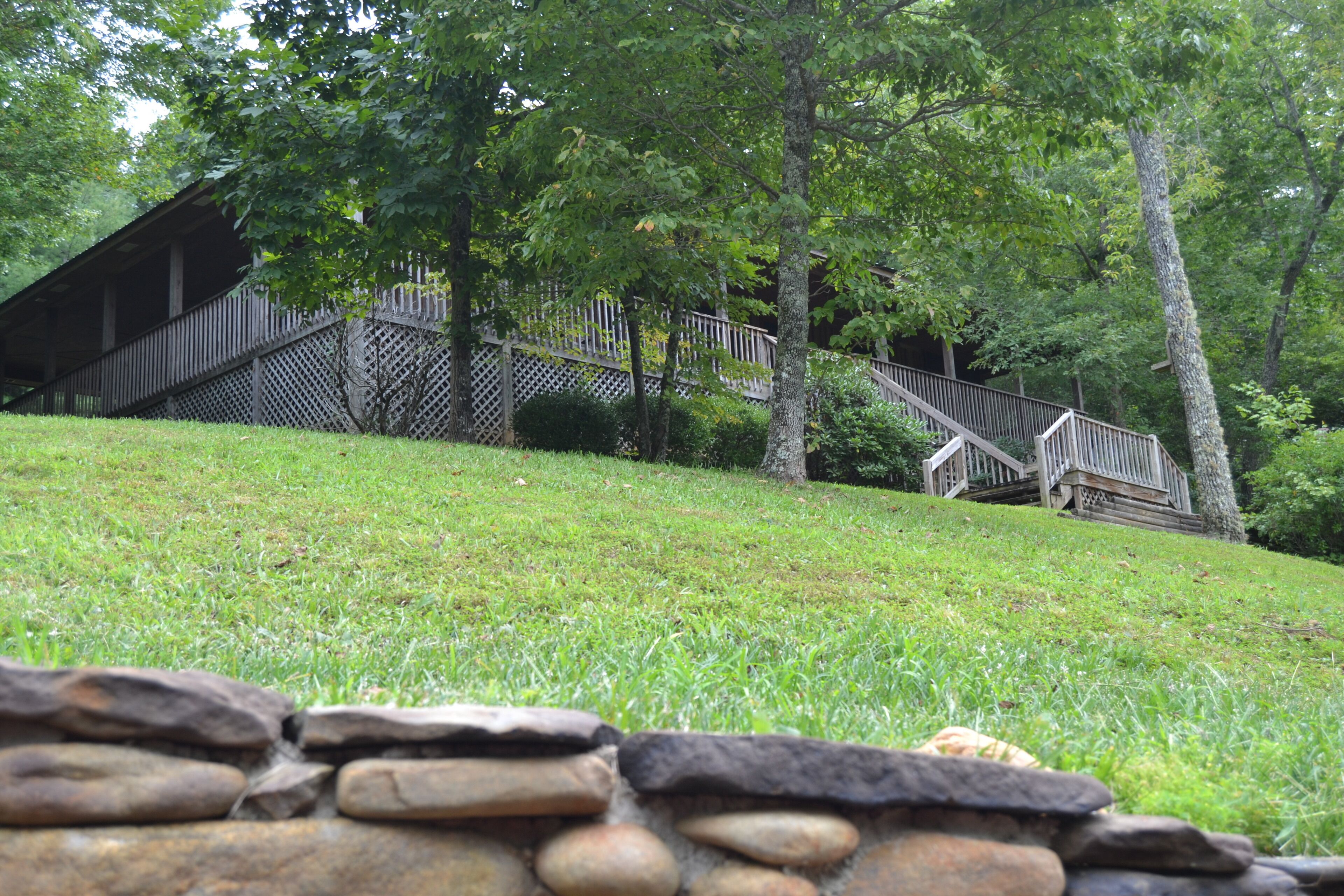 A rustic wooden building with a wooden staircase leading up to a covered porch.