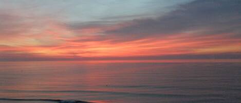 A sunset over a calm sea with a clear horizon.