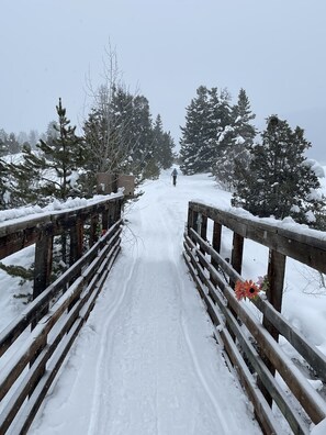 A wooden bridge with snow-covered railings leading to a forested area. - Ski Condo on Main Street Park City - 1BR/1BA. Walk to Lifts & Dining (Park City)
