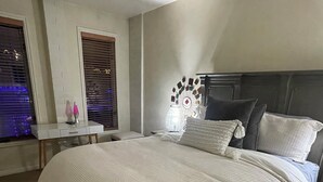 Un dormitorio con una cama grande, mesitas de noche y un elemento decorativo en la pared.