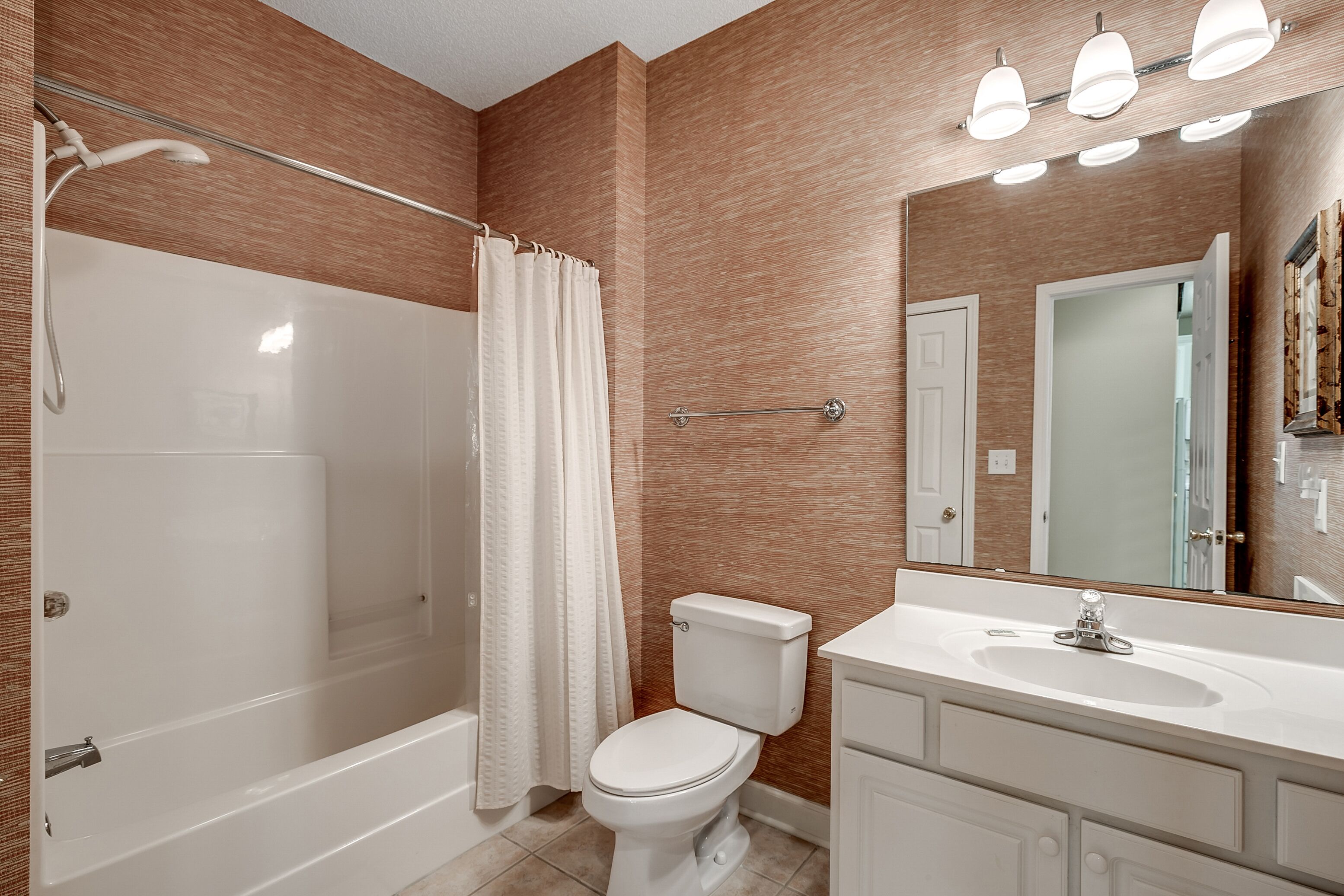Une salle de bain avec une baignoire, des toilettes et un meuble-lavabo avec un miroir.