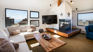 Una sala de estar moderna con un televisor grande, asientos cómodos y una chimenea.