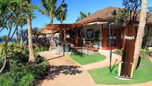 Een resort met een overdekte zitplek buiten, een zwembad en een gebouw met de aanduiding 'Duke's'.