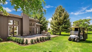A modern house with a patio, a golf cart, and a well-maintained lawn. - Large Townhouse on 18th green beautiful location near canyon, quiet neighborhood (Jerome)