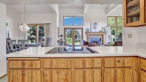 Una cocina moderna con una isla grande, armarios de madera y vistas al exterior.