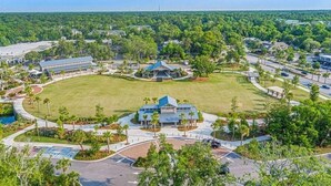 An aerial view of a resort with a central grassy area, multiple buildings, and surrounding greenery. - SOUTH FOREST BEACH. Coligny, pool. walk to beach. updated. sleep 8. 
SURF COURT (Hilton Head Island)