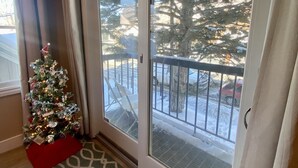 A room with a large sliding glass door leading to a balcony, a Christmas tree, and a patterned rug. - Luxury Heart Of Old Town 3-Bdrm+ HOT TUB Walk To Skiing Chairlift Dining Main St (Park City)