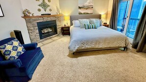 A bedroom with a large bed, a fireplace, a ceiling fan, and a view of the outdoors through a sliding glass door. - Luxury Heart Of Old Town 3-Bdrm+ HOT TUB Walk To Skiing Chairlift Dining Main St (Park City)
