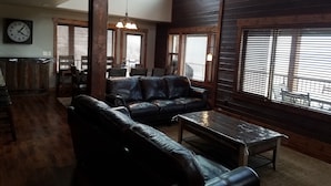 Ein geräumiges Wohnzimmer mit Ledersofa, Couchtisch und Essbereich mit Holzmöbeln.