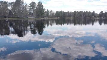 Un lago tranquillo con i riflessi degli alberi e un cielo sereno.