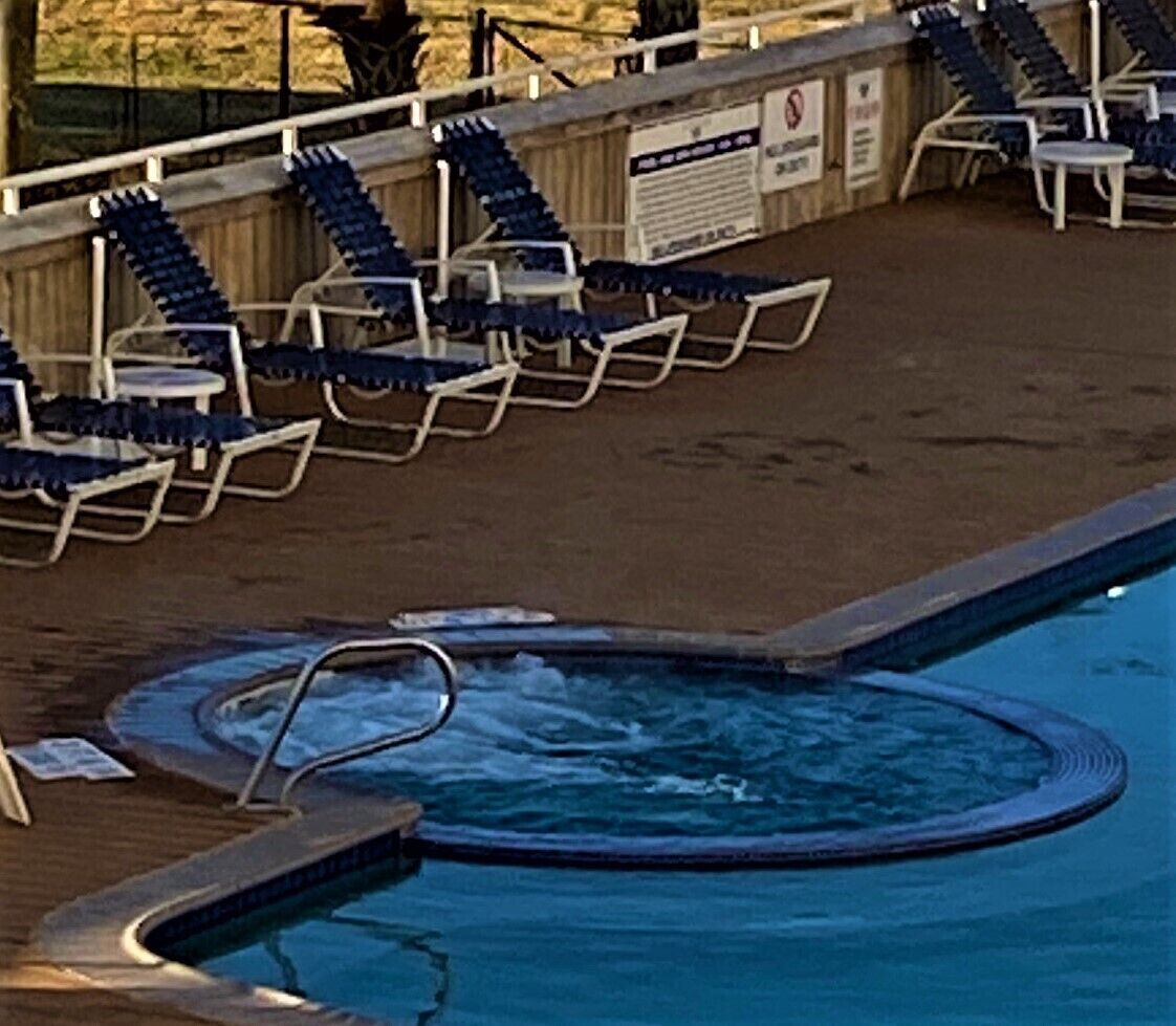 Une piscine avec des chaises longues et un jacuzzi.