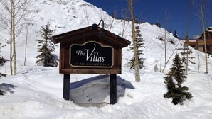 A wooden sign for 'The Villas at Mt. Crested Butte' in a snowy landscape.
