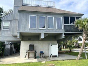 A two-story house with a balcony, a garage door, and a small outdoor area with a lawn.