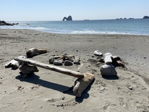 Une plage de sable avec de gros rochers et une structure en bois.
