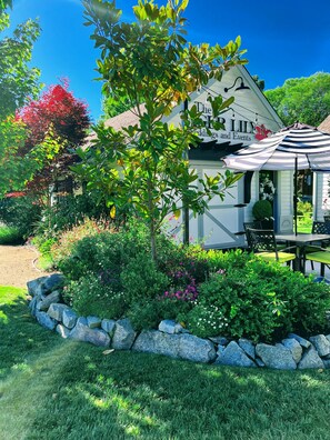 A house with a sign for "The Lily Weddings and Events" and a patio with outdoor seating. - TIGERS DEN -  #1 BEST LOCATION, ROMANTIC, STUNNING, STEPS TO BRITT FESTIVAL (Jacksonville)