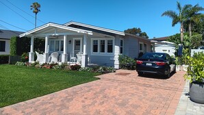 A residential house with a covered porch, a car parked in the driveway, and a well-maintained lawn. -  Laguna Home at Shaw's Cove, Ocean View, Quiet street, Short walk to beaches



 (Laguna Beach)