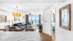 Een ruime woonkamer met uitzicht op zee, een eettafel en een groot raam.