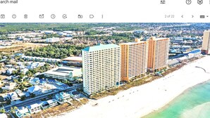 Vista aérea de una zona costera con playa, varios edificios altos y una combinación de estructuras residenciales y comerciales.
