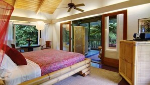 A bedroom with a bed, a ceiling fan, a desk, and a view of the outdoors. - Tropical Romance... Lush Gardens.... in Heavenly Hana, Maui (Hāna)