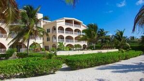 A resort with a multi-story building, a pool, and palm trees. - Oceanfront First Floor 2 Bed/2 Bath - Free use of Kayaks (San Pedro)