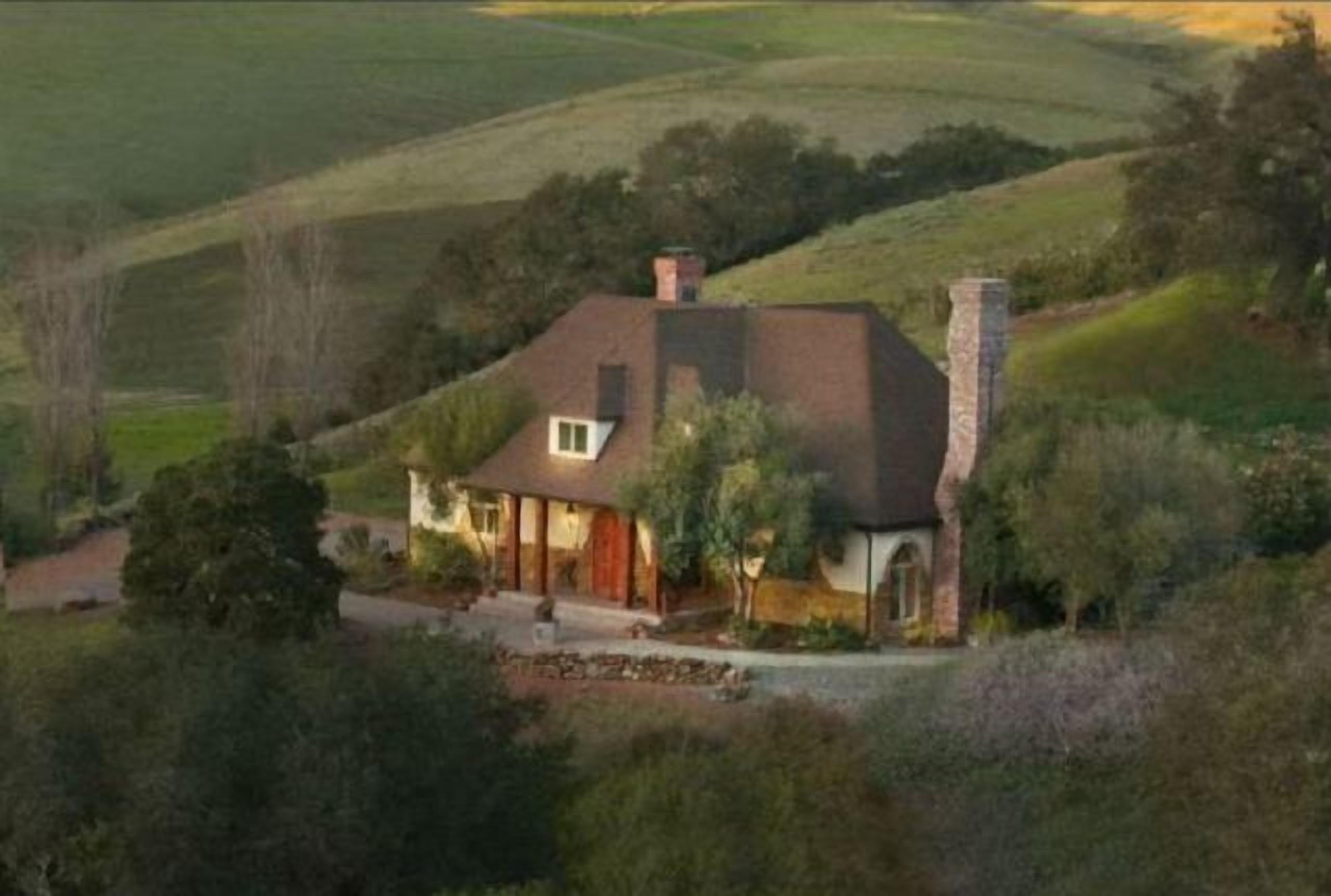 A single-story house with a sloped roof, a chimney, and a well-maintained lawn.
