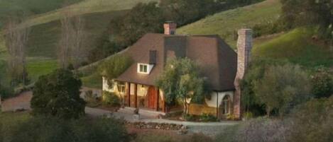 A single-story house with a sloped roof, a chimney, and a well-maintained lawn.