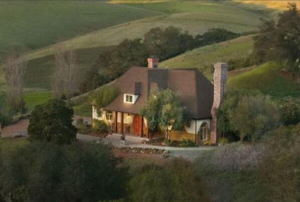 A single-story house with a sloped roof, a chimney, and a well-maintained lawn. - Luxury home on 400 Acre Ranch (San Luis Obispo)