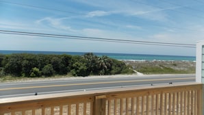 A coastal road with a wooden fence and a view of the ocean. - TOWNHOUSE IN BEAUTIFUL SUNNYSIDE BEACH (Panama City Beach)