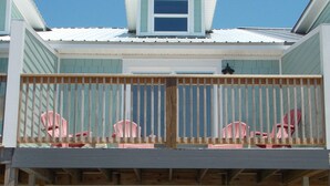 A two-story house with a balcony, a door, and two white chairs. - TOWNHOUSE IN BEAUTIFUL SUNNYSIDE BEACH (Panama City Beach)