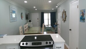 A kitchen with a stove, oven, and a dining table with chairs. - TOWNHOUSE IN BEAUTIFUL SUNNYSIDE BEACH (Panama City Beach)