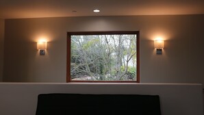 Una habitación con ventana, dos luces fijadas a la pared e iluminación empotrada en el techo.