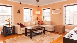 A living room with a sofa, coffee table, and a ceiling fan.