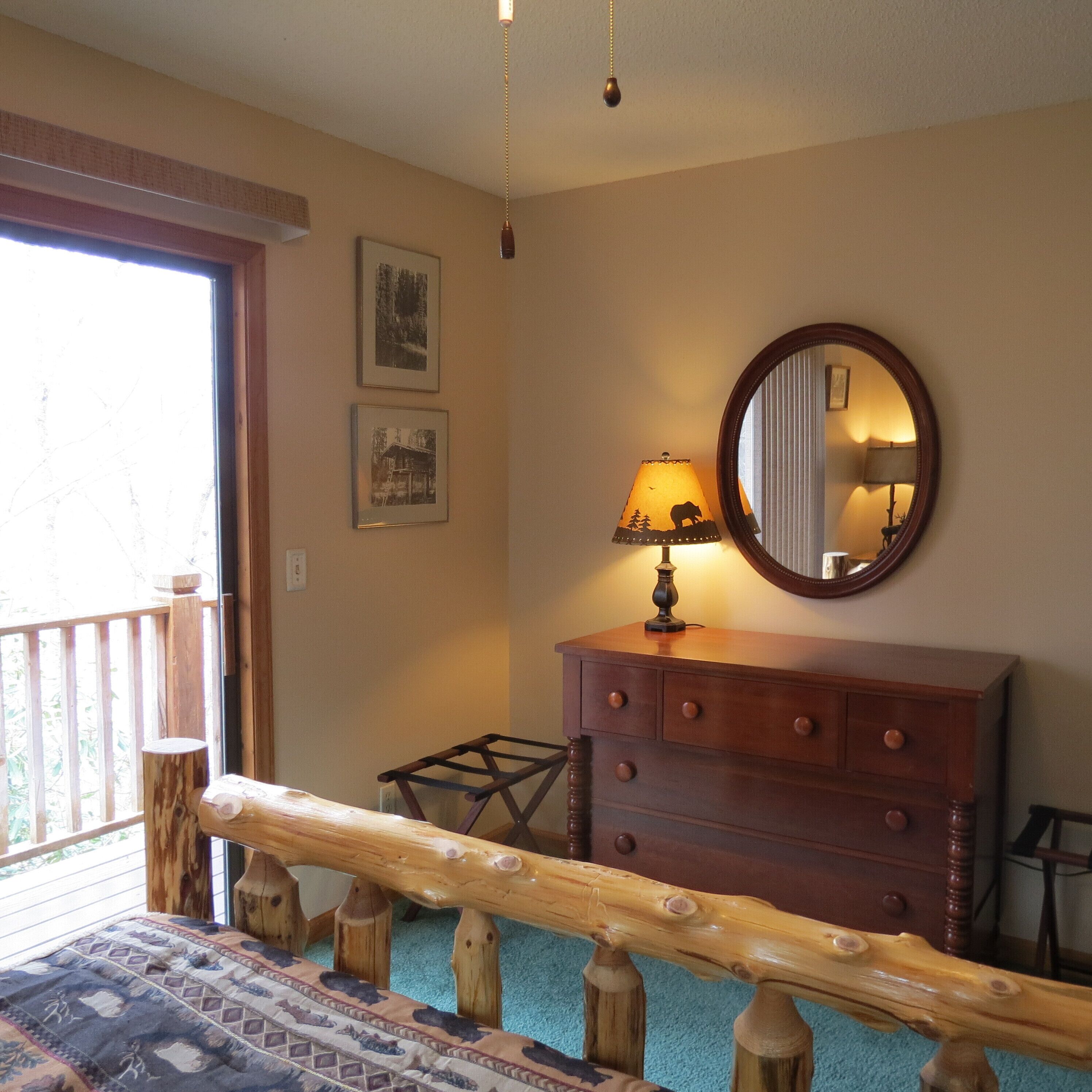 A bedroom with a wooden dresser, a mirror, and a bed with a wooden headboard.