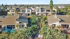 A residential area with multiple houses featuring modern architecture, a central pathway, and surrounding greenery.