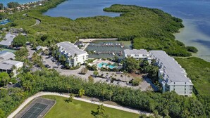 An aerial view of a resort with multiple buildings, a swimming pool, and a marina.