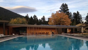 A swimming pool with lounge chairs and a covered seating area. - Your home away from home at Black Butte Ranch! (Sisters)