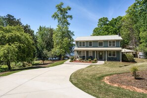 A two-story house with a front porch, a driveway, and a well-maintained lawn. - Fabulous views on nice cove! Easy short walk to dock. Outdoor kitchen & fire pit (Gainesville)