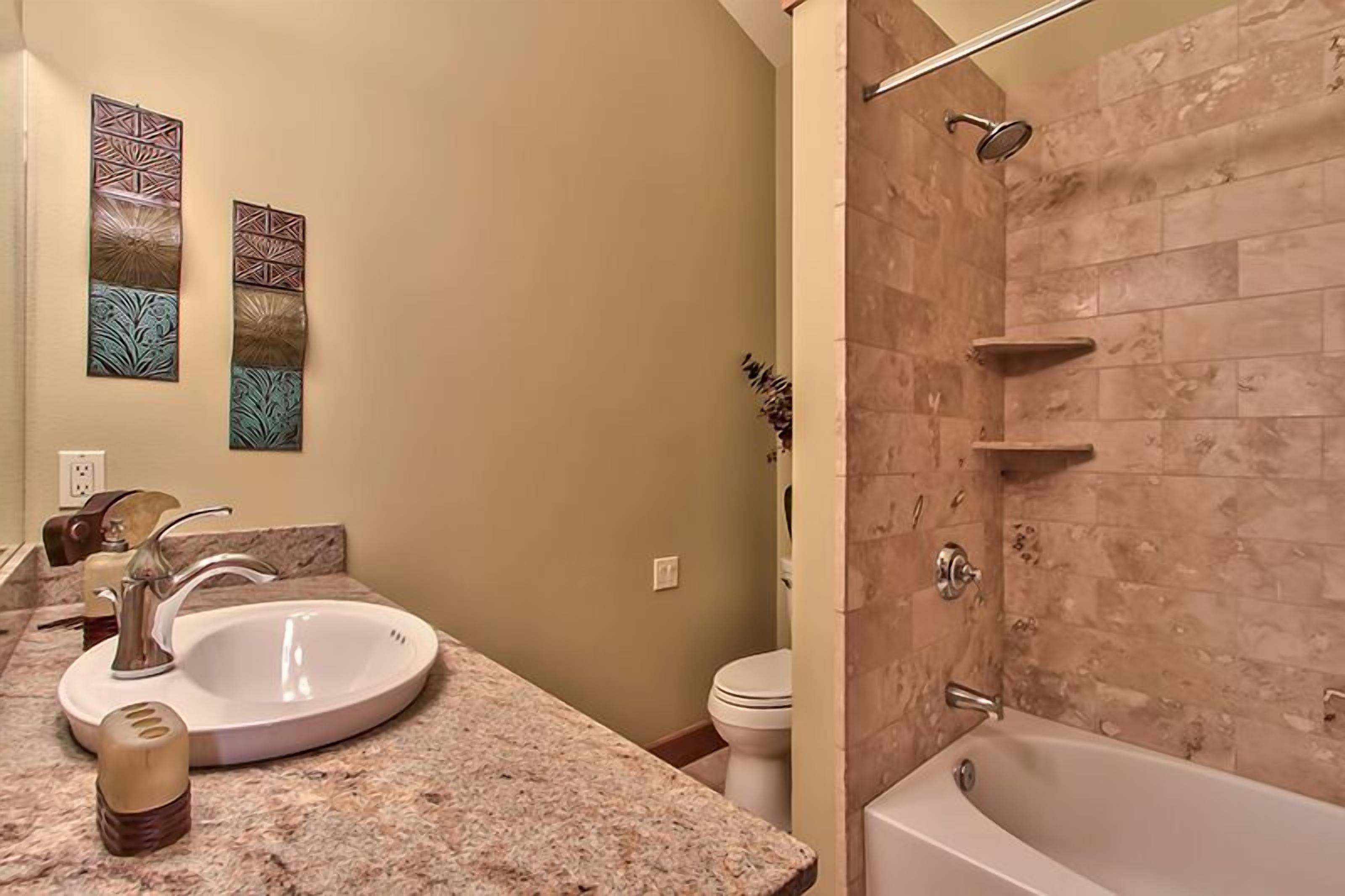 A bathroom with a sink, toilet, and bathtub.