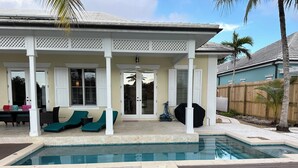 A covered patio with a pool, lounge chairs, and a ceiling fan. - Luxurious 'Old Fort Bay' Large SINGLE LEVEL with 4 bedrooms each with an ensuite (Old Fort Bay)