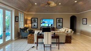 A spacious living room with a wooden ceiling, a ceiling fan, a flat-screen TV, a dining table, and two sofas. - Luxurious 'Old Fort Bay' Large SINGLE LEVEL with 4 bedrooms each with an ensuite (Old Fort Bay)