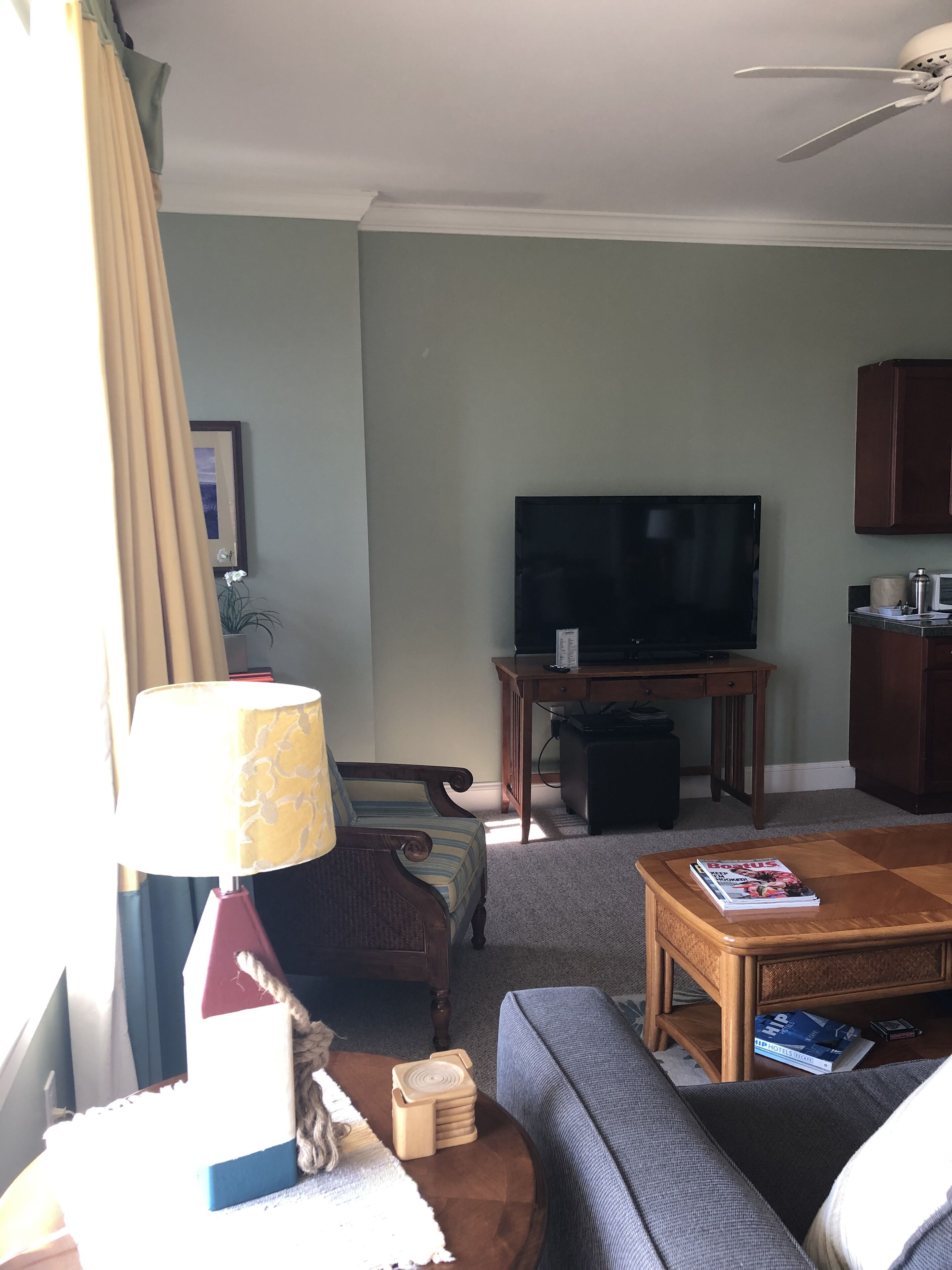 A living room with a television, sofa, coffee table, and a lamp.