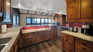 Un'ampia cucina con mobili in legno, un'isola grande e vista sull'esterno.