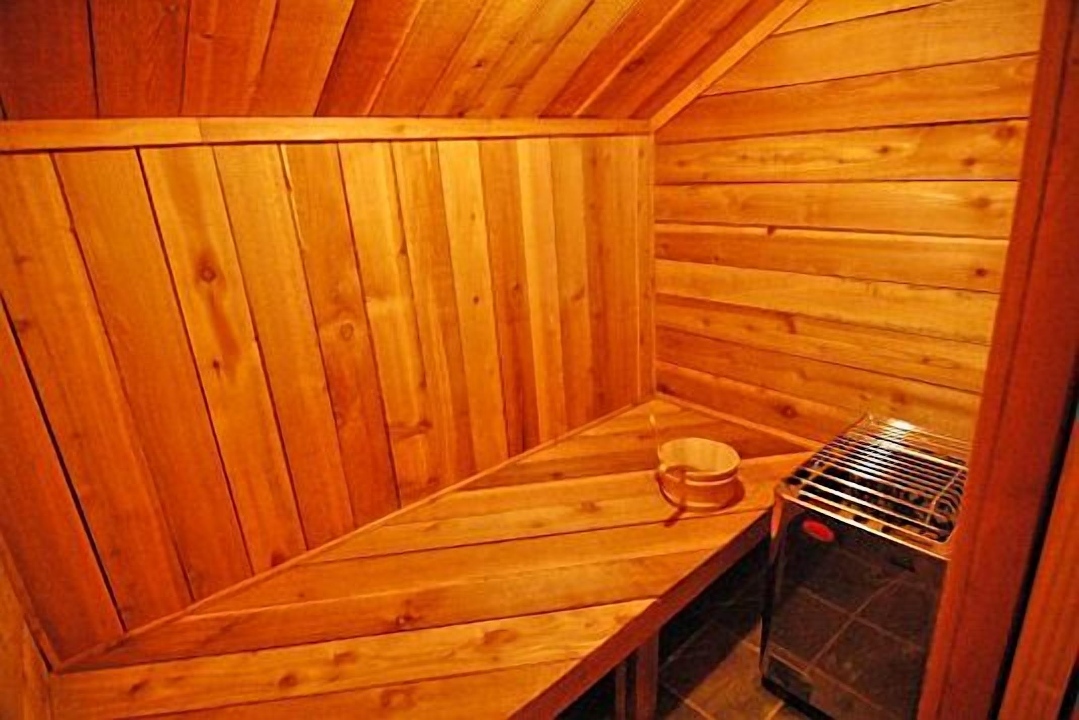Un sauna en bois, équipé d’un banc et d’un appareil de chauffage.