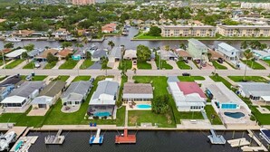 Un quartier résidentiel avec des maisons, un port de plaisance et un grand bâtiment en arrière-plan.